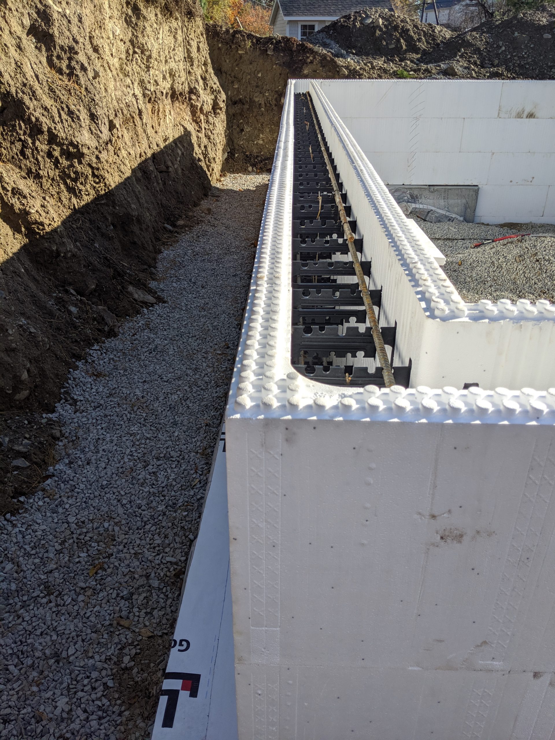 Five layers of ICF blocks are visible in this ICF foundation. Rebar is seen place on the top layer of the ICF blocks with interconnecting plastic molds,