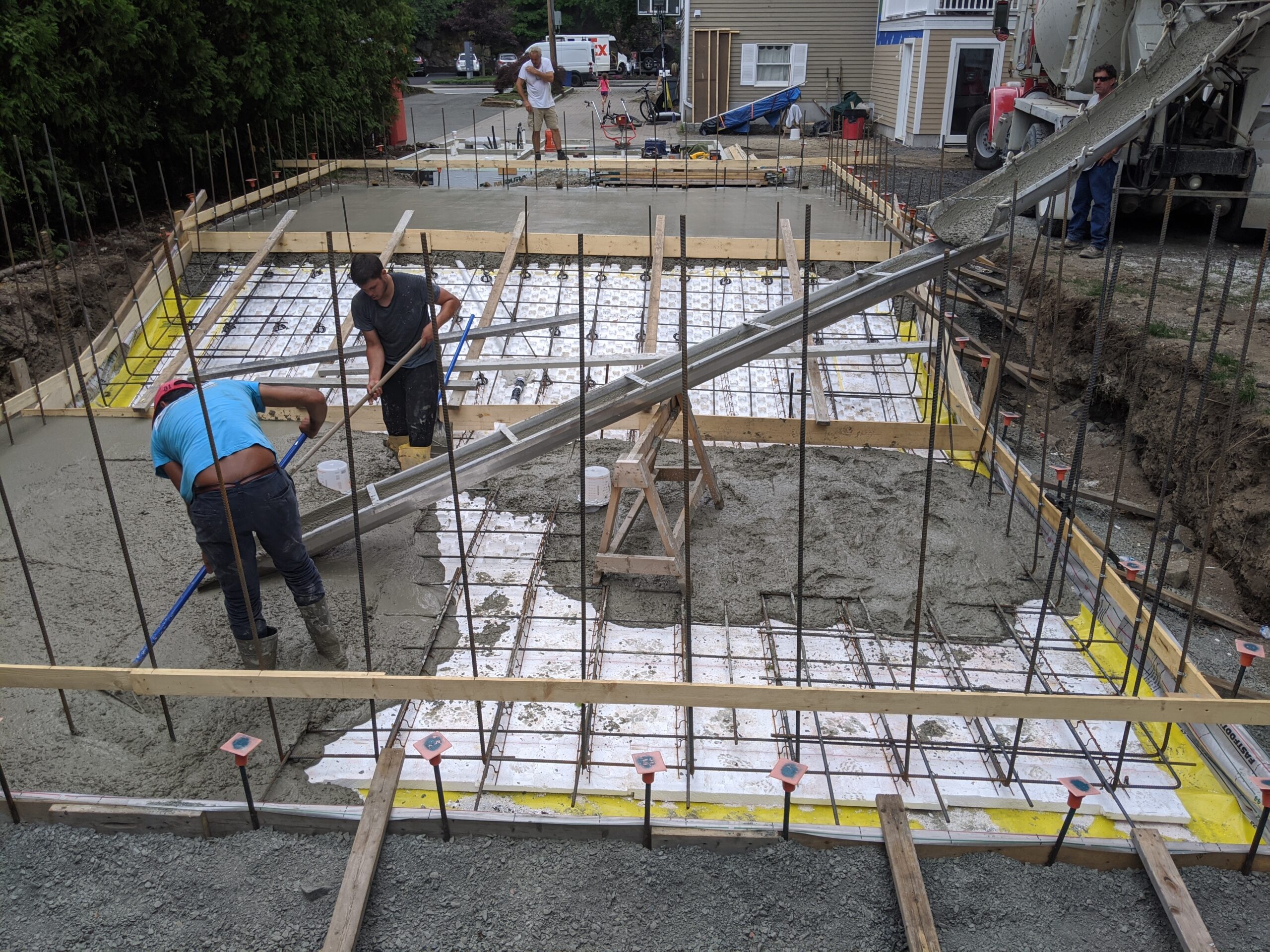 A team of workers laying out the concrete as it is poured in the base layer of a new pool that will be built with ICF forms.