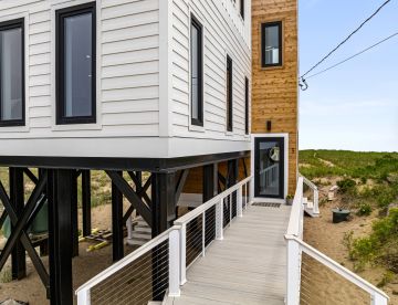 Front Entrance of a Plum Island ICF Home painted in white with a wooden exterior