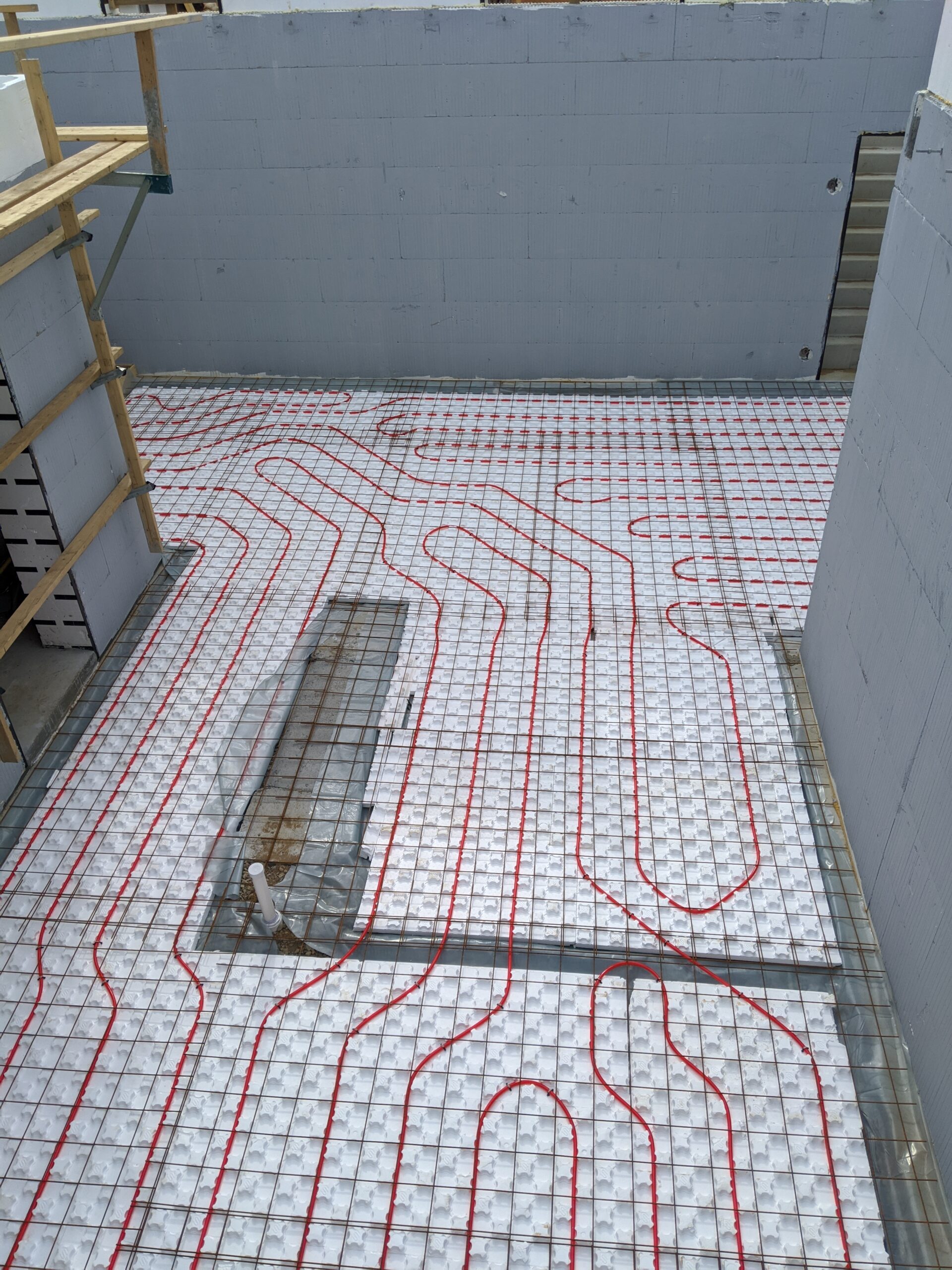 A view of the basement foundation with a radiant heating system within the concrete structure.