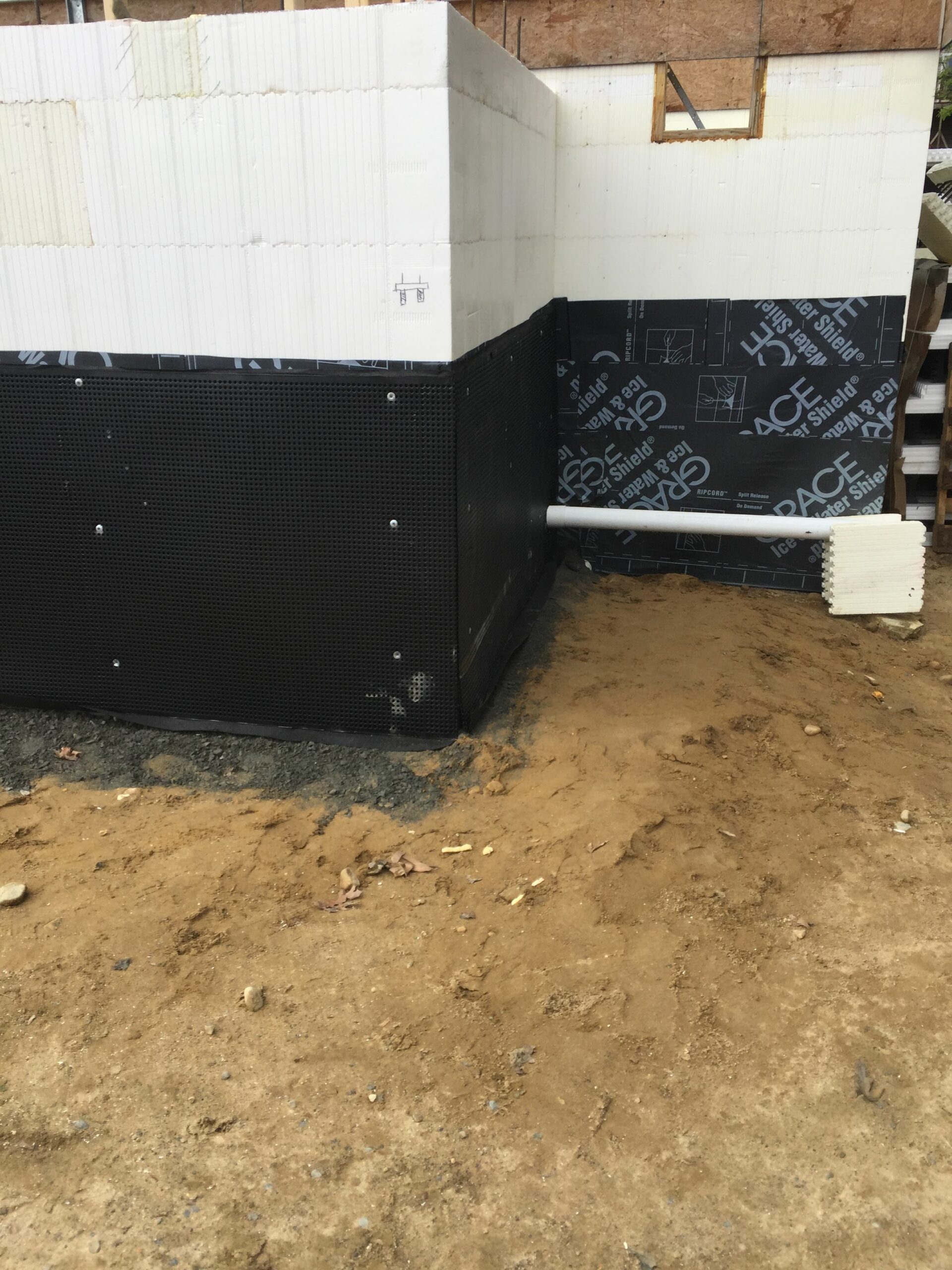 various waterproofing elements are seen on the side of an ICF home, including waterproof adhesive sealant with a plastic mould used for waterproofing on top of it.