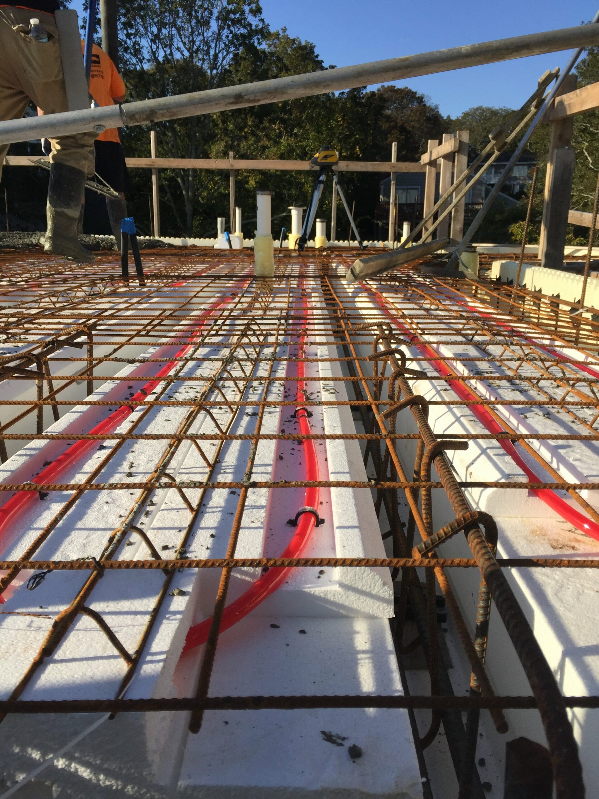 radiant floor heating integrated into ICF floor forms with a steel rebar grid above it preparing for an ICF concrete pour.